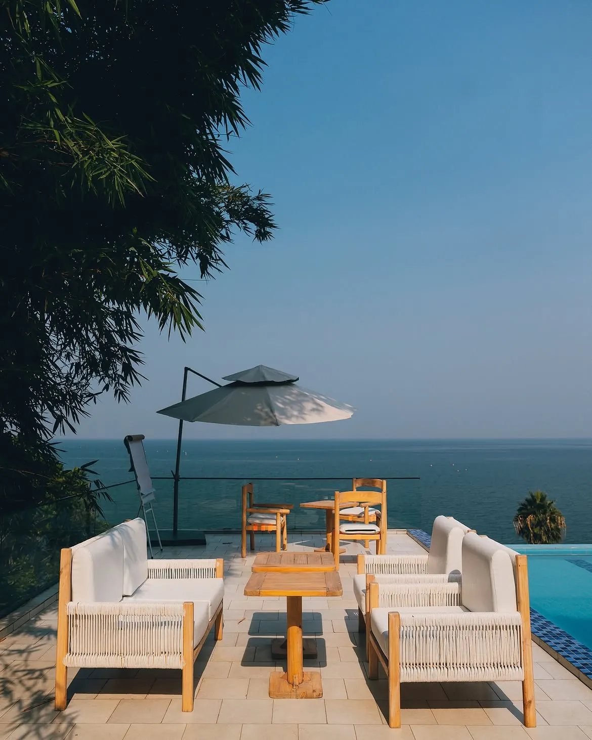 Terrace lounge chairs beside the infinity pool at B&P Ever Retreat Villa, overlooking Lake Kivu