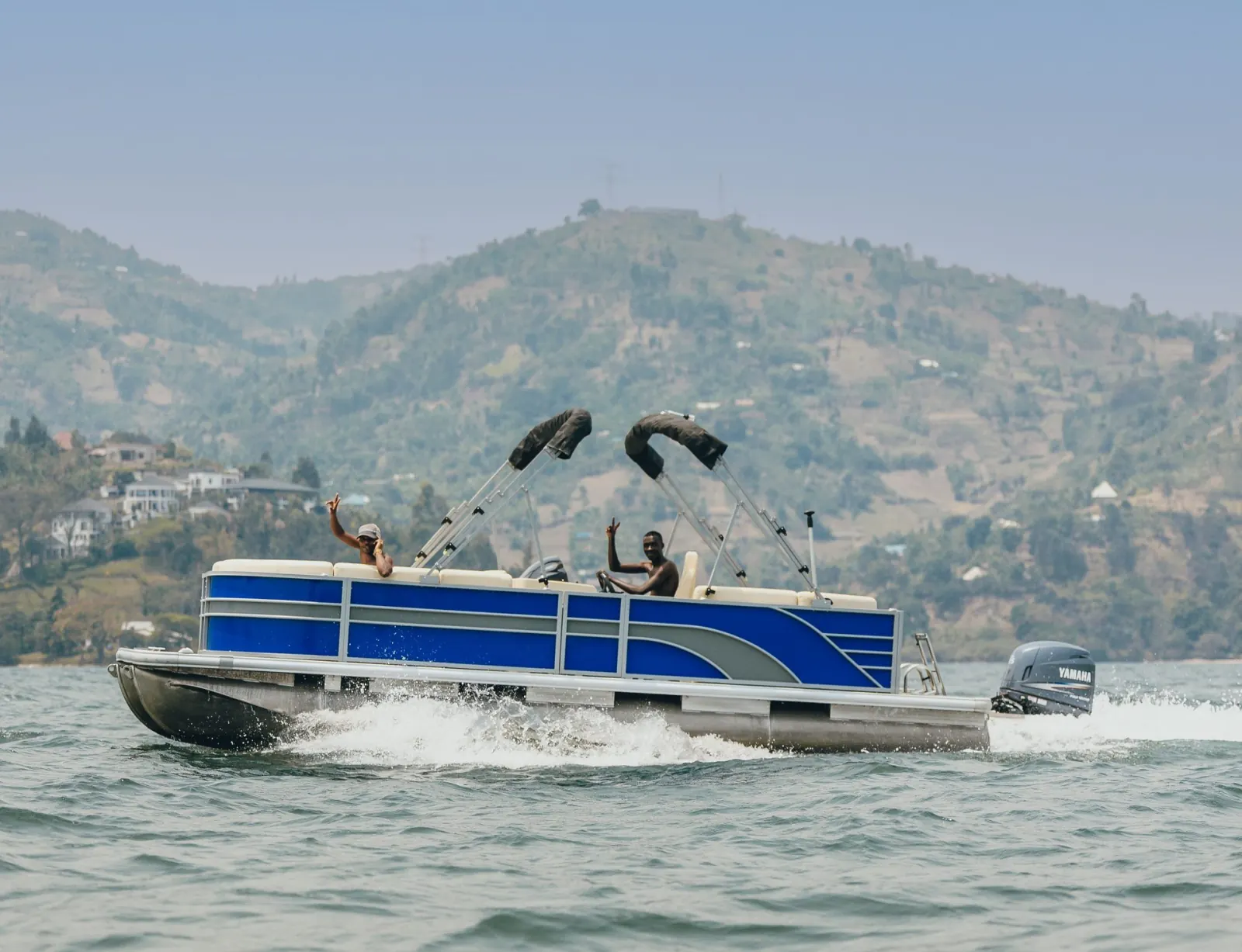 Boat trip on Lake Kivu near Rubavu, with green hills behind