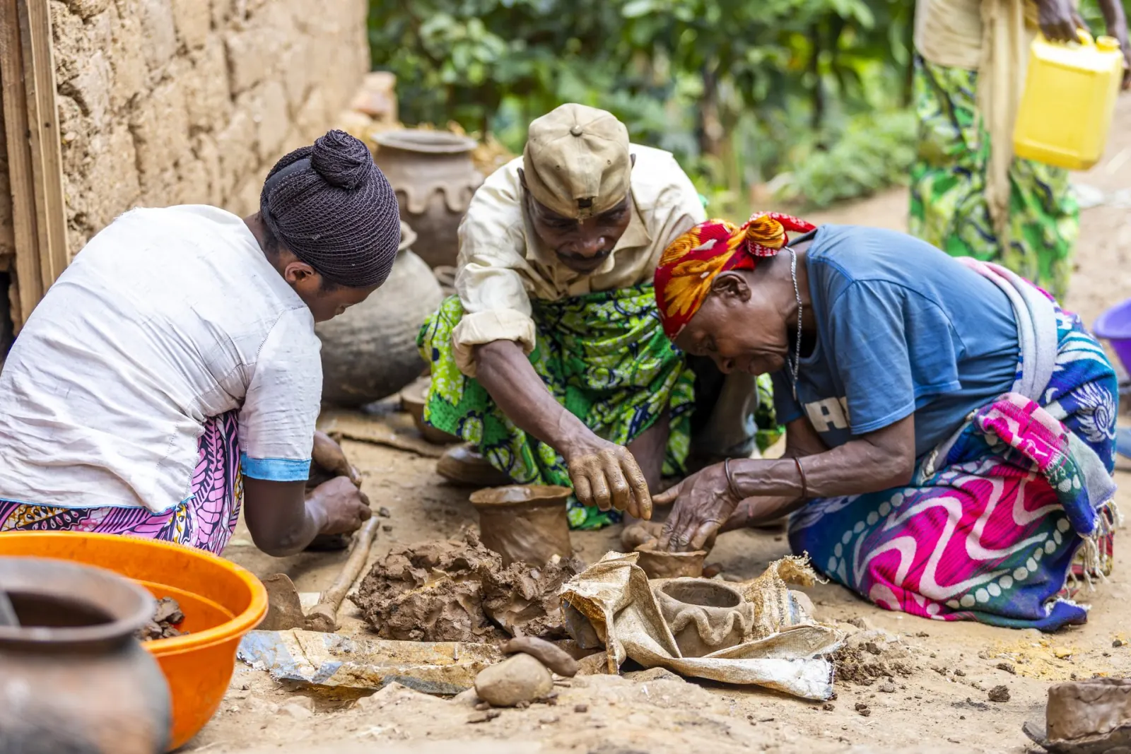 Rwandan women shaping clay pots by hand at a pottery workshop